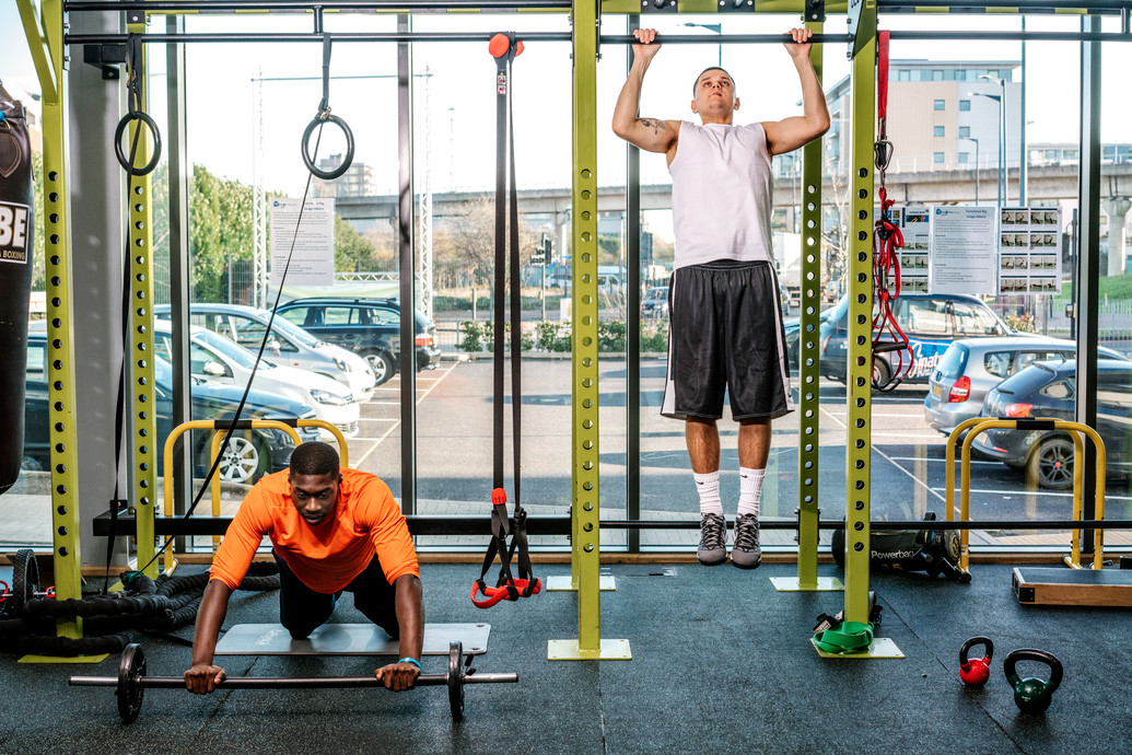 Two men work out on equipment