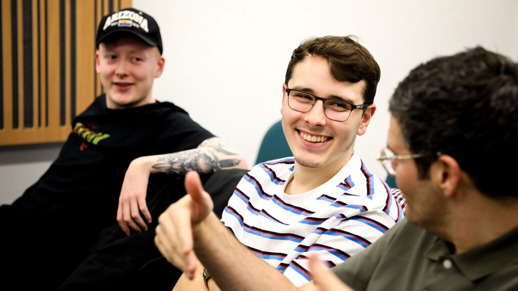 Three male students smiling and laughing