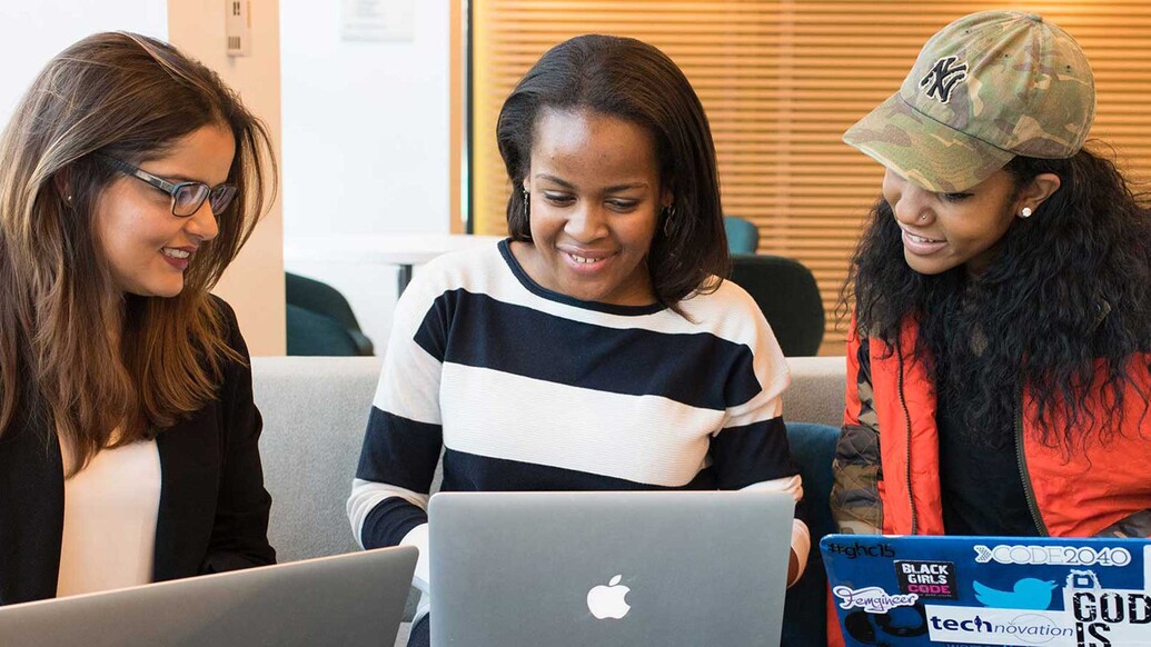 Three female students working on laptops