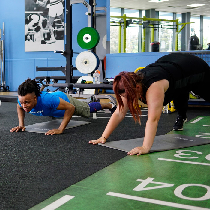 Two people doing the plank in an exercise class.
