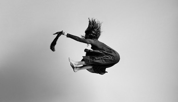 Arts Researching, woman jumping high in the air, black and white photograph