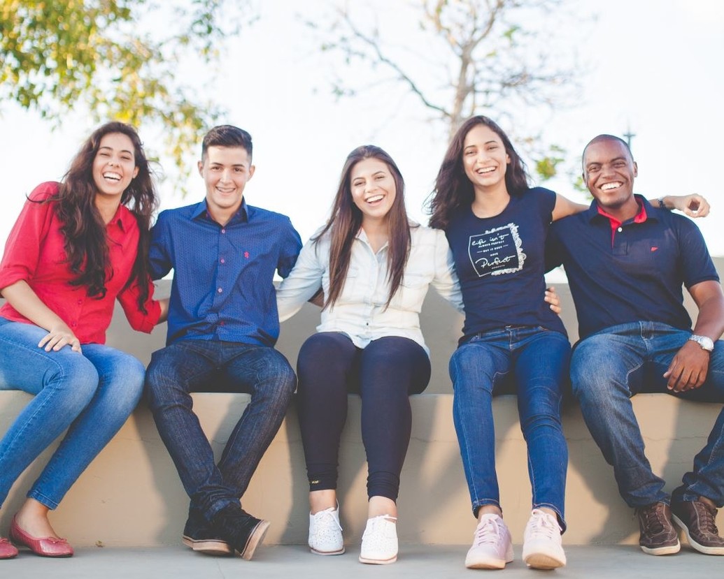 Group of students sitting outside smiling
