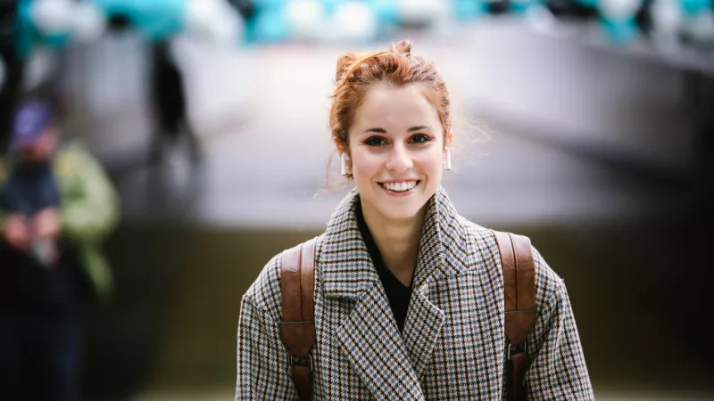 Poster of Woman smiling in front of campus
