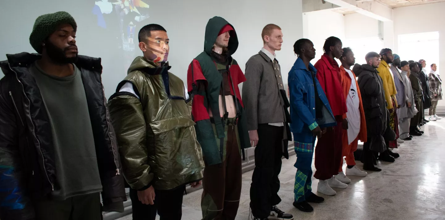 A line of fourteen models wearing outfits designed by students at UEL.
