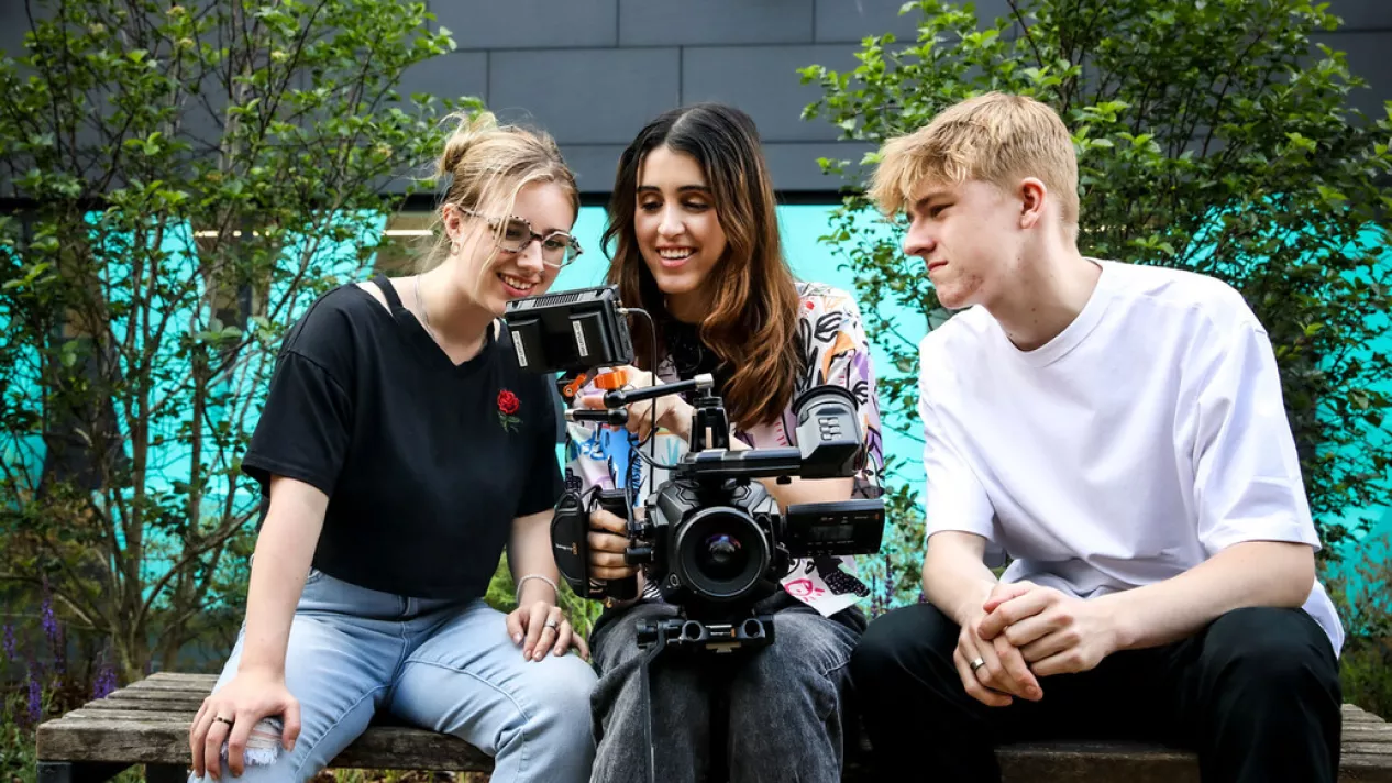 Three students with camera