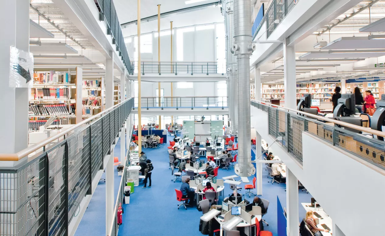 A wide-angle shot of students sitting at various tables in the Docklands Campus Library.