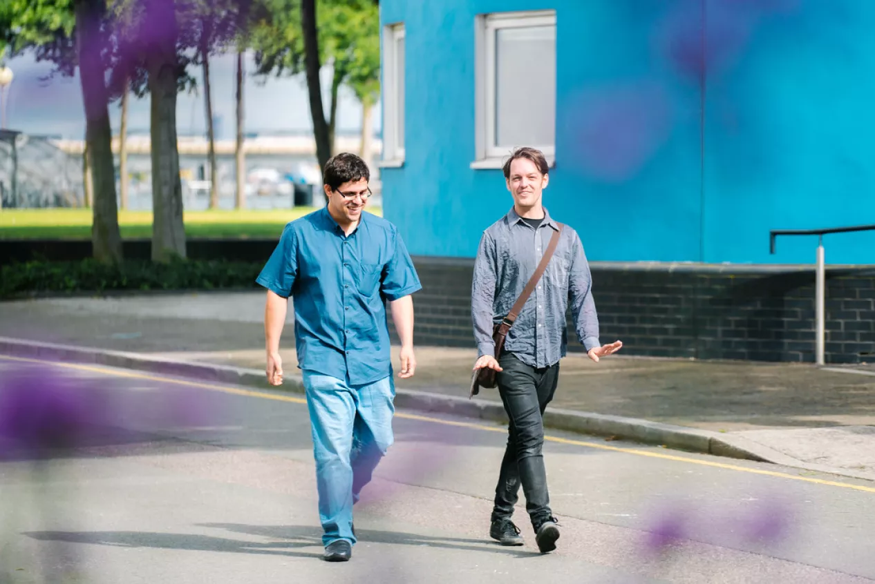 Two male students walking across campus