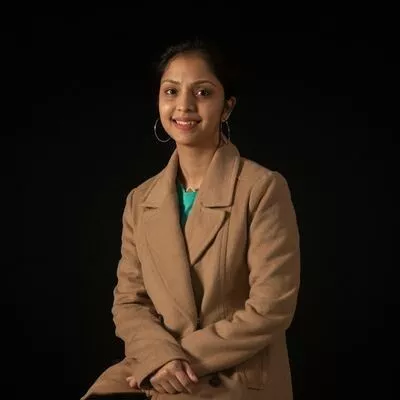  a woman in a tan coat posing for a picture. 