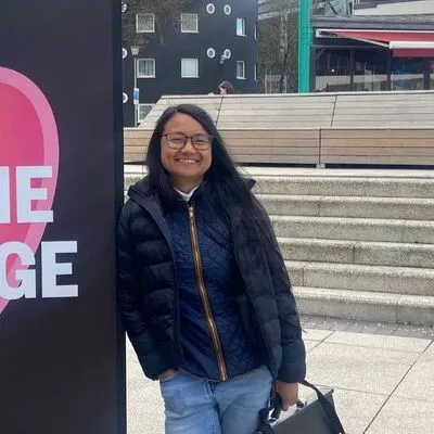  a woman standing next to a sign with a heart on it. 
