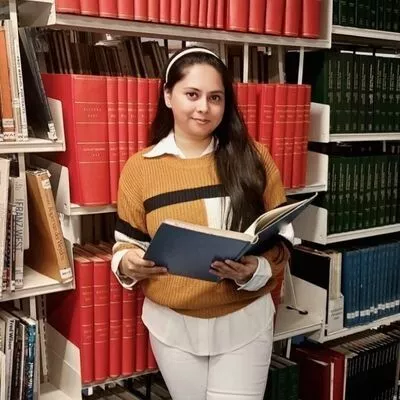  a woman in a library holding a book. 