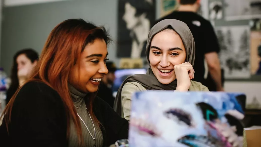 Two female students smiling and laughing